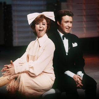 Entertainer und Sänger Peter Alexander und Sängerin Caterina Valente sitzen nebeneinander und posieren für die Kamera.