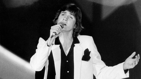Johnny Logan singt beim ESC 1980 das Lied "What's another year" in ein Mikrofon. 
