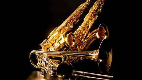 Zwei Saxophone, eine Trompete und eine Posaune liegen auf dem Boden