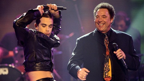 Tom Jones und Robbie Williams tanzen 1998 gemeinsam auf der Bühne.