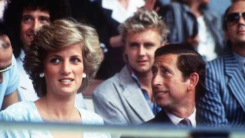Beim legendären Live Aid Konzert im Londoner Wembley Stadion waren auch Lady Diana und (damals noch) Prinz Charles dabei. Im Hintergrund sehen wir hier Brian May und Roger Taylor von Queen. | 40 Jahre Live Aid: Das größte Rockkonzert der Geschichte 