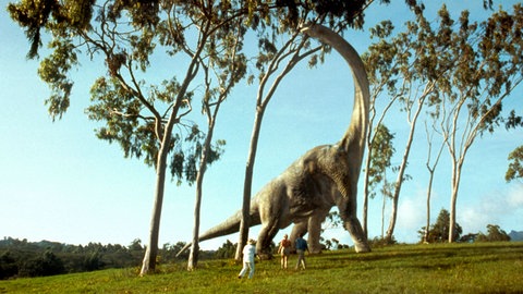 Ein Filmstill aus "Jurassic Park" mit einem Langhals-Dinosaurier