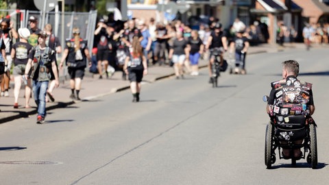 Ein Rollstuhlfahrer in Kutte auf der Hauptstraße in Wacken