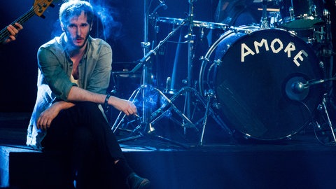 Sänger Marco Wanda raucht neben Schlagzeug