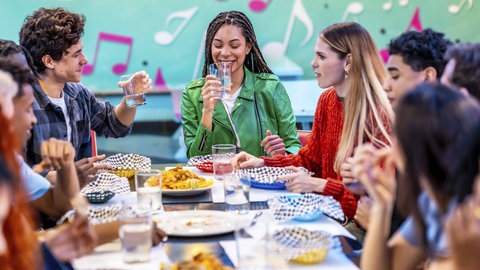 Gruppe in Restaurant mit Musiknoten im Hintergrund