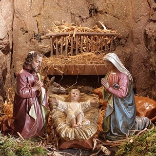 Das Jesus-Kind in der Krippe zusammen mit Maria und Josef