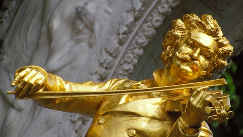Vergoldete Johann-Strauss-Statue mit Geige im Wiener Stadtpark.