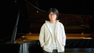 Magdalene Ho (stehend vor einem Flügel)