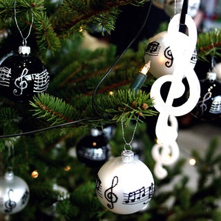 Weihnachtskugeln mit Noten hängen an einem Weihnachtsbaum