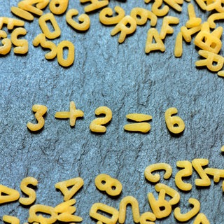 Buchstabennudeln bilden Rechenaufgabe, Mathematik
