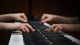 Hände einer jungen Pianistin die auf der Klaviatur eines Steinway & Sons-Flügel spielt, Stuttgart, Baden-Württemberg.
