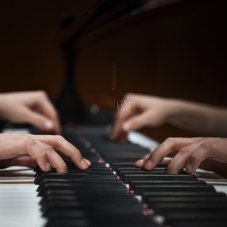 Hände einer jungen Pianistin die auf der Klaviatur eines Steinway & Sons-Flügel spielt, Stuttgart, Baden-Württemberg.