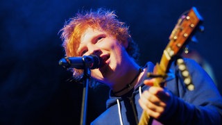Ed Sheeran singt in ein Mikrofon |  Die traurige Geschichte hinter Ed Sheerans erstem Hit "The A Team"
