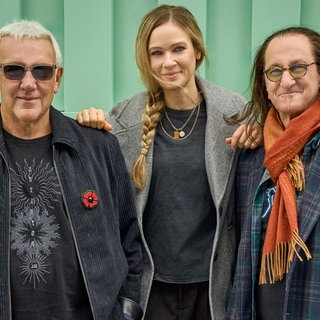 Gitarrist und SängerBassist der Band Rush mit der deutschen Schlagzeugerin Anika Nilles