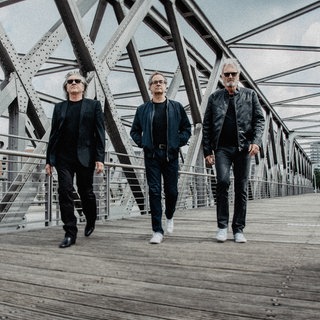 Die drei Bandmitglieder von Frontm3n laufen über eine Brücke