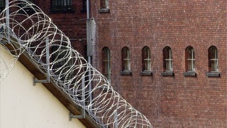 Stacheldraht vor der Fassade einer Justizvollzugsanstalt