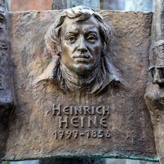 Eine Skulptur des historischen deutschen Schriftstellers und Dichters Heinrich Heine auf dem Heimatbrunnen in der Stadt Düsseldorf, Deutschland.