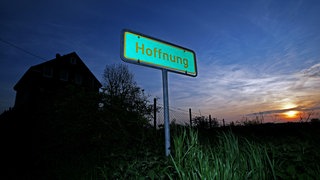 Ein Schild mit der Aufschrift "Hoffnung" steht am Straßenrand vor einer Gebäudesiedlung bei Wermelskirchen, aufgenommen am 03.05.2008.