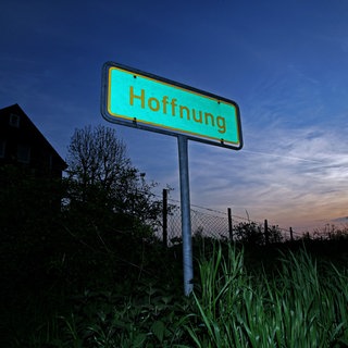 Ein Schild mit der Aufschrift "Hoffnung" steht am Straßenrand vor einer Gebäudesiedlung bei Wermelskirchen, aufgenommen am 03.05.2008.