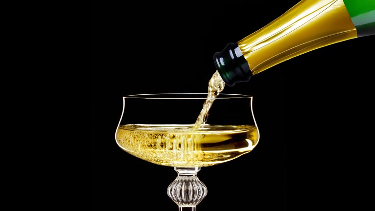 Champagner wird in eine Champagnerschale gegossen