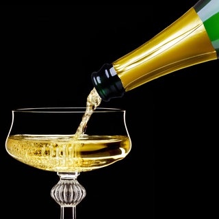 Champagner wird in eine Champagnerschale gegossen
