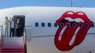 Mick Jagger (l-r), Ronnie Wood und Keith Richards von den Rolling Stones steigen aus ihrem Flugzeug. Archivfoto.