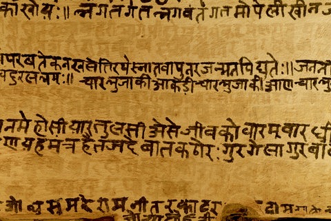 Eine Mauer trägt eine Inschrift auf Sanskrit.