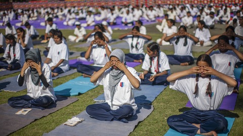 Schülerinnen und Schüler aus Indien machen gemeinsam Yoga.