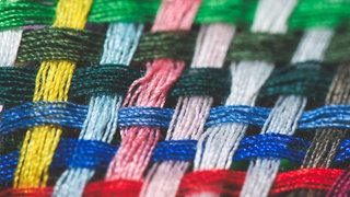 Detail eines Gewebes aus farbigen Kett- und Schuss-Fäden:  "Strich und Faden" hängt damit zusammen, dass sich das Gewebe aus zwei sich kreuzenden Fäden zusammensetzt. Die nennt man "Strich" und "Faden". Der Ausdruck kommt also aus der Schneiderzunft.