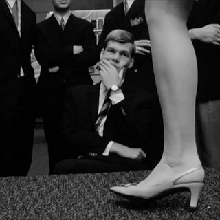 Ein Mann in dunklem Anzug schaut sich eine Modenschau an