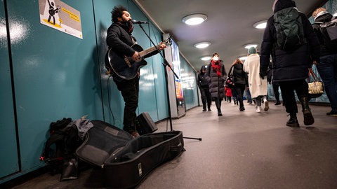 Ein Straßenmusiker in einer Fußgängerpassage