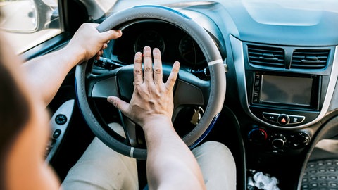 Nahaufnahme eines hupenden Autofahrers | Wenn die Hupe nicht nur warnt, beginnt die Agression im Straßenvekehr.