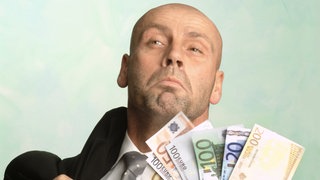 Ein Mann gibt mit einer Handvoll Geldscheine an | Kommunikation: Was tun, wenn Angeber loslegen?