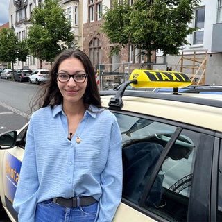 Sarah Hofmann vor einem Taxi