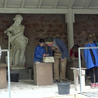 Kinder bei einem Steinmetz am werkeln