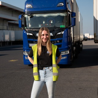 Frau steht vor ihrem Truck