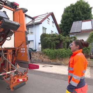 eine Frau am Müllauto