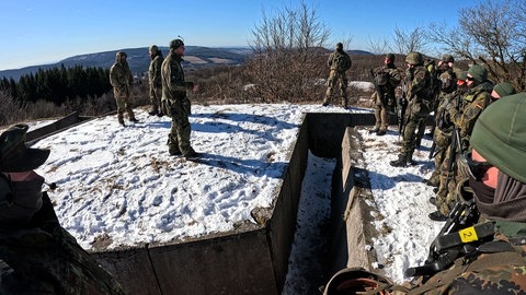 Bei der Spezial-Grundausbildung stehen die angehenden Jäger-Soldaten um einen Graben.