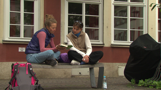 Berufsschülerinnen sitzen auf einer Bank und Lernen