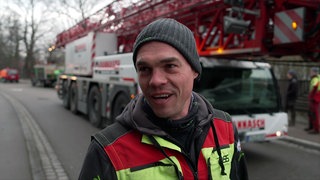 Baumpfleger Johannes Wehrle steht vor einem Spezialkran