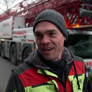 Baumpfleger Johannes Wehrle steht vor einem Spezialkran