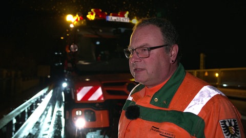 Mitarbeiter der Straßenmeisterei Langenau steht beim Winterdienst frühmorgens vor seinem Einsatzfahrzeug