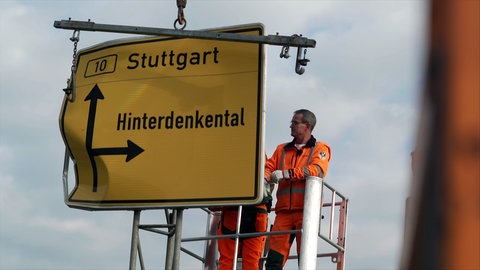 Mitarbeiter der Straßenbahnmeisterei Langenau tauschen an der B10 ein Straßenschild aus