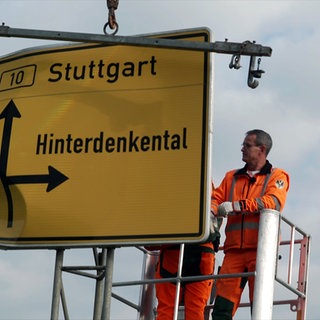 Mitarbeiter der Straßenbahnmeisterei Langenau tauschen an der B10 ein Straßenschild aus