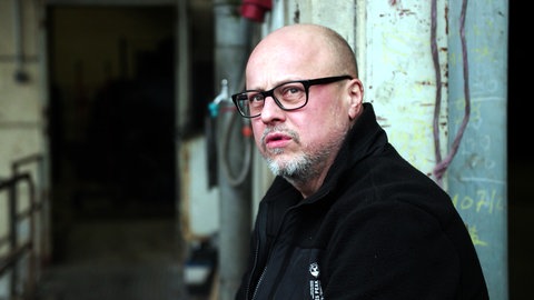 LKW-Fahrer Christian steht vor einer Ladehalle