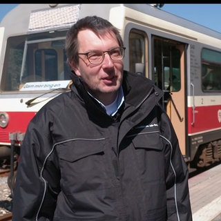 Jörg Schmid wagt den Quereinstieg als Lokführer. Er steht vor dem Schwäbischen Alb-Bahn.