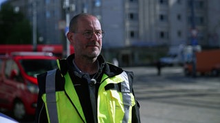 Edgar Schultz überwacht das Liniennetz der Freiburger Verkehrsbetriebe VAG. Er steht auf der Straße und trägt eine gelbe Warnweste.