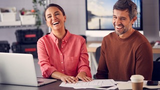 Eine Kollegin und ein Kollege haben Spaß an der Arbeit | Wie wir die Freude an der Arbeit wiederfinden