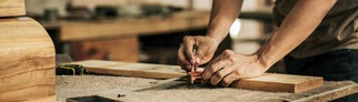 Ein Schreiner zeichnet ein Brett an | Wie man im Handwerk gut verdient, Karriere macht und glücklich wird