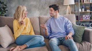 Paar sitzt auf der Couch und redet